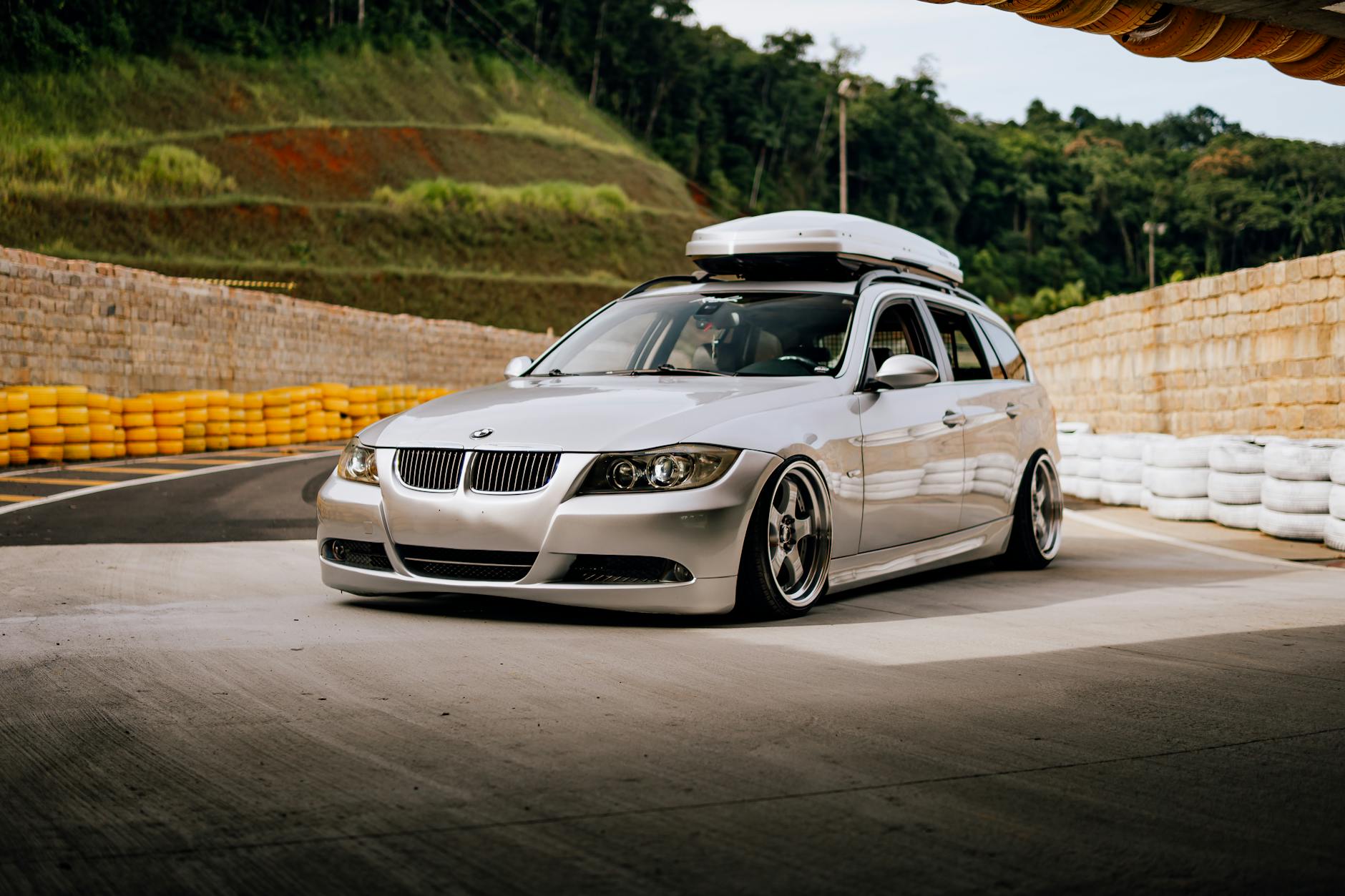 Srebrne kombi BMW z boksem dachowym zaparkowane na zlocie aut