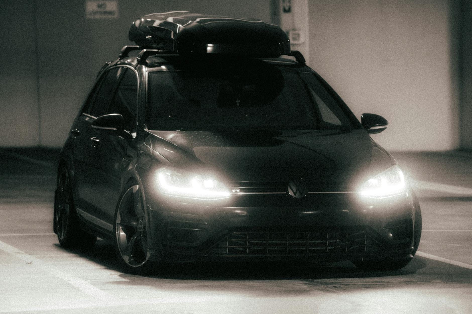 Ciemny samochód z włączonymi światłami w podziemnym parkingu